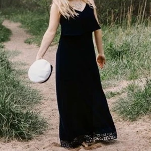 Mörkblå maxiklänning - Mörkblå maxiklänning från Vila. Spetts längst ner på klännings nederkant. Öppen rygg med sicksack-mönster.