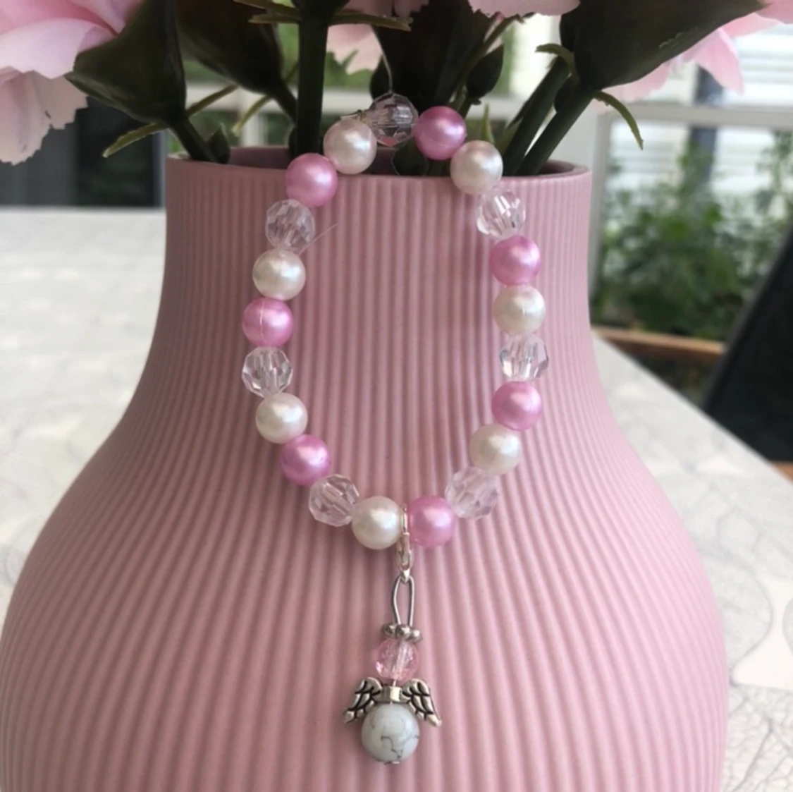 Rosa armband med lyckoängel