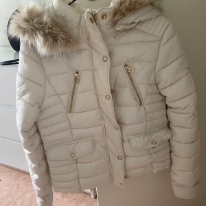 Vinterjacka från zara - En beige/vit jacka med guld detaljer från zara. Strl xs. Den är aldrig använd 