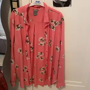 En rosa skjorta med blommor på. Köpt på Lindex- storlek M. Använd fåtal gånger, fint skick.