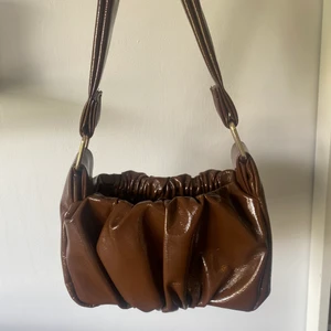 Asos väska Brun - Brun lackad Axelväska i 70-tals stil från Asos. Finns en en korthållare inuti (se bild). Super fin men kommer inte till användning. Helt oanvänd. Buda i kommentarerna 🍂🌼