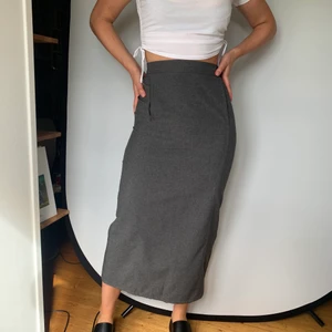 Grå kjol - Midi kjol i grått som är second hand. Den har en slits i bak som gör den enkel att röra sig i och den har en stor ficka i fram. Jag är 174 cm och stl 36. Frakt är inkluderat i pris