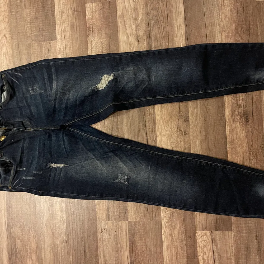 Blå jeans med slitningar, använda ett fåtal gånger storlek 25. Det är lite stretch i jeansen. Jeans & Byxor.