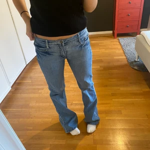 Lågmidjade jeans - Ett par blåa lågmidjade jeans med söta diamant detaljer både på rumpan och vid fickorna där fram. Dom är köpta second hand. Storleken står inte i men dom är långa för mig och jag är 164. Har använt dom fåtal gånger men eftersom dom är second hand är dom inte helt i nyskick. Möts i Sthlm annars står köparen för frakten☺️☺️