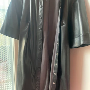 Pu läder klänning  - Från Hm, pu läder ( imitation) stl M. Finns två hällor där det finns ett pu band som jag har men byter ut till annat bälte vid användning. Bandet tillkommer som hörtill 