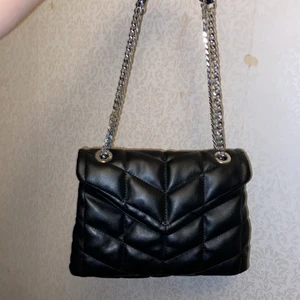 Axelremsväska svart justerbara band  - Parfois axelremsväska. Nyskick eftersom jag bara använd några få gånger.  Köpt för 399kr på zalando, nu slutsåld. 23cm i höjd och 32 i längd.