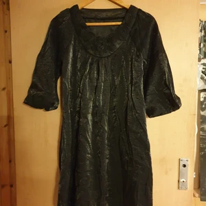 Halloween snyggaste klänning vintage - Snyggaste halloween klänningen i glansigt tyg liknar lite sammets.med 3 kvart armar med mudd fantastiskt collage vid halsen av svarta blommor läng från axeln till slut är 92 cm.passar från S-M,Missa inte denna skapelse..bilder gör den inte rättvis.