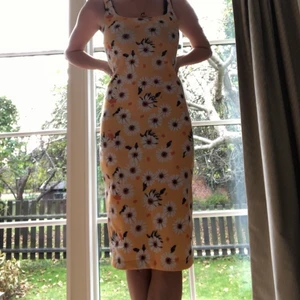 Långklänning - Blommig långklänning, gul med vita prestkragar på. Stretchig slits där bak. Jag hade en likadan fast svart som jag klippte av, blev lika snyggt.