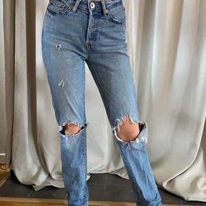 Blåa knä håliga jeans  - Säljer dessa blåa jeans med hål vid knäna och låren, säljer dessa pågrund av att de blivit för små i midjan. Använda ca 5 gånger ( köparen står för frakten) 