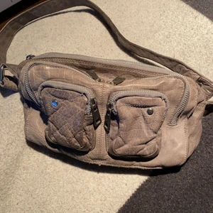 Nunoo väska - Grå nunoo väska i modellen Ellie washed. Köpt för cirka 2 år sedan, gott skick. Får plats med väldigt mycket i denna väskan och den är perfekt till allt! 