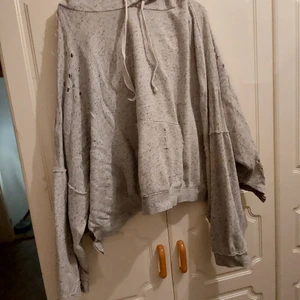 Huvtröja från hm  - En kort huvtröja från HM. Den är väldigt pösig. Det är "hål" över hela tröjan. Storlek XL. Den har "slits" på både sidorna av tröjan. Sliten look. 