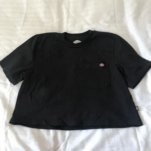 Svart croppad T-shirt från dickies - Svart croppad T-shirt från dickies i storlek S. Endast använd 1 gång så i absolut nyskick! Nypris ca 250kr. Har en liten ficka på bröstet😇