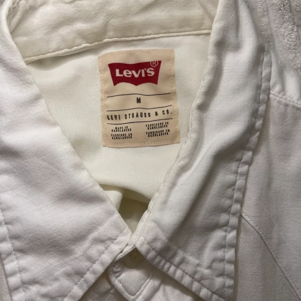 Vit Levi’s skjorta med tryckknappar. Lite i western stil med fickorna och över axlarna. Tunn och skön för sommarn och gör sig väldigt bra till jeans. Frakt tillkommer. Skjortor.