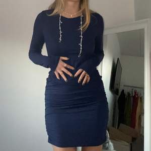 Marinblå figursydd klänning som går att både dra upp till kortare modell eller lite längre formellare. Köparen står för frakt