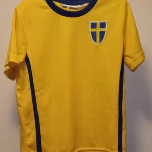 Fotbolls T-Shirt Storleken 86/92 - Varumärke: Sverige  Storlek: 86/92  Vara: T-Shirt    Färg: Gul & Blå  Pris: 10kr  Tillkommer Frakt & Porto