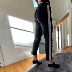 Kostymbyxor - Kostymbyxa med vid och beige rand längs bägge sidor. Något små för mig som är 172, men insydda i midjan för att ”krama om” svanken. Passar S och kortare än 172.