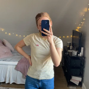 Randig t-shirt  - Relativt ny levis t-shirt med slim passform. Gula och vita ränder. 