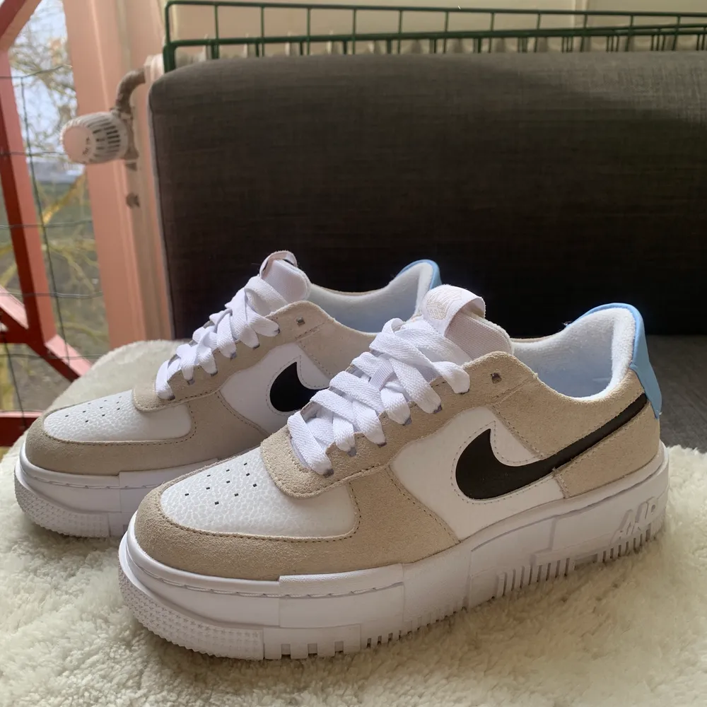 Beige/vita Nike Air Force Pixel med ljusblå detalj på hälen. Så otroligt fina men tyvärr för små. . Skor.