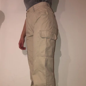 Cargopants - Beiga cargopants från second hand. Lite långa i benen för mig som är 161. Stora fickor på sidorna och på bakfickorna