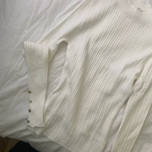 Stickat vit tröja från fashionova - Vit stickat med fina guldknappar vid armar, aldrig använd