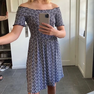 Blommig klänning - Jättesöt och skön klänning. Materialet på denna är såå skönt, kan bäras både off shoulder och vanligt, aldrig använd, prislapp kvar. 