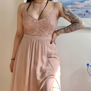 Balklänning i storlek 38 - Jättefin gammelrosa balklänning med paljettdetaljer och slits på ena benet. Endast använd en gång så den är i bra skick. Frakt ingår ej i priset.