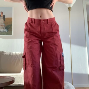 Adidas flare pants - Så coola vida adidas byxor. Typ roströd färg med fickor på sidorna. Aldrig använda, helt nyinköpta. Storlek 32/XS men tror dom är rätt stora i storleken för dom passar mig som brukar ha 36 på byxor.