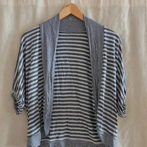 CARDIGAN - En cardigan som slutar vid armvecket. Snyggt över ett linne till ett par jeans!