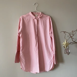 En rosa skjorta ifrån HM i strl 44  - En rosa lång tröja ifrån HM, skjortan har bredare ärmar. Skjortan är i bra skick. 