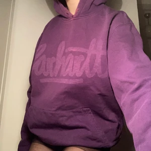Lila carhartt hoodie💜 - Så fin carhartt hoodie! Använder inte så mkt därför säljer jag. Oversized & sitter jättefint!💕 Den har en svag blekningsfläck och liten slitning vid kragen som man ser på bilden, men annars bra skick. Skriv privat vid frågor eller fler bilder!