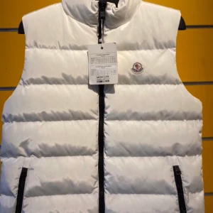 Väst moncler   - Jätte fin vit Moncler väst, finns i alla storlekar. Leverans 3 veckor. frakt ingår i priset
