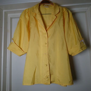 Vintageblus - Gul vintageblus med spets vid ärmsluten. Lite puffärm. En knapp fattas, se sista bilden, om köparen vill så kan jag sy dit knappen som sitter längst ner innan den skickas, jättefin att ha nedstoppad i byxor och då syns det inte🌻