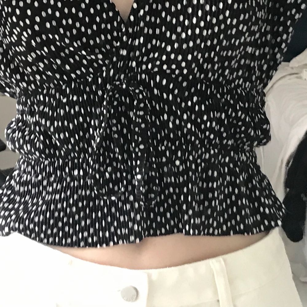 En söt svart v-ringad zara blus med vita prickar, den är som ribbad och har resår i midjan så att man får figur. Den har också snörning men det är endast en detalj (går alltså inte att spänna åt). Ärmarna är puffiga. Kommit till användning max två gånger och är helt som ny. Den är storlek M men passar bra på mig som också är s/xs. På första bilden är volangen längst ner instoppad, men inte på sista bilden. Snyggt bägge två enligt mig 🤎. Blusar.