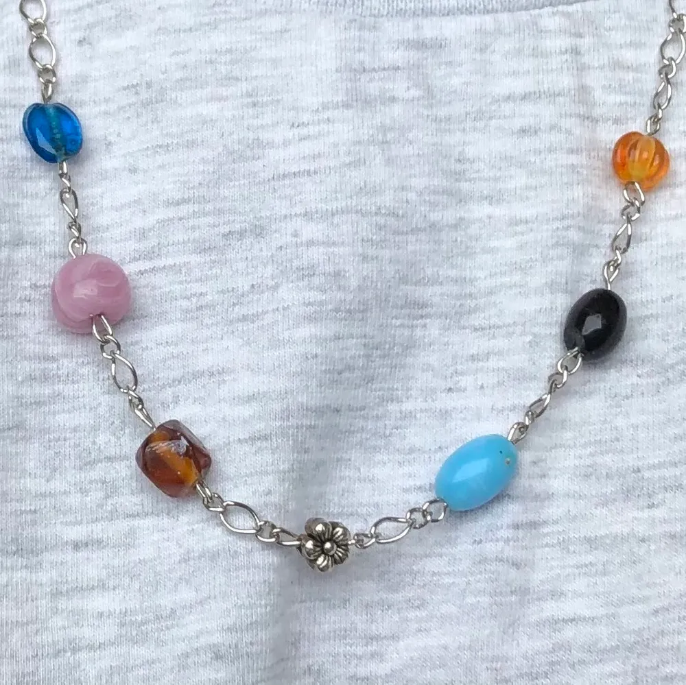 Halsband med glaspärlor i olika färger och en liten blomma i mitten. Säljer för 80kr + 12kr frakt🌺. Accessoarer.