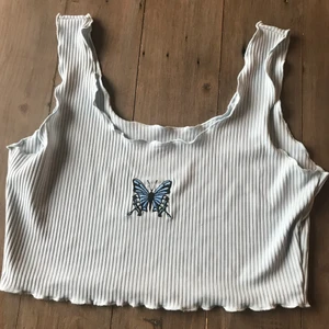 Fjärils linne  - Ett blått tunt linne som är ribbat och har en fjäril i mitten🦋                  Köparen står för frakten 