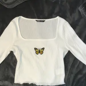 En vit långärmad fjärils tröja från SHEIN, Är inte als använd och är kort i ärmarna på mig som är 166. Stolek XS, köpt för 99kr🔥