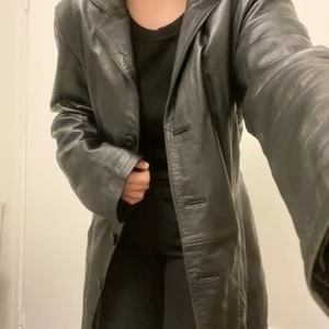 Svart goldstein skinnkappa  - Svart skinkappa/lång skinnjacka från Goldstein by Molltan. Köpt second hand och knappt blivit använd då jag har fler liknande. Står ingen storlek men uppskattar till S-M, sitter luftigt/oversized på mig som har S så inga problem att få plats med en tjocktröja under. Frakt tillkommer på bud. DIREKTPRIS 500 INKL FRAKT 