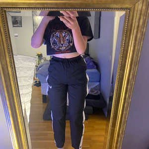 Nike byxor - Svarta Nike byxor med knappar på sidan