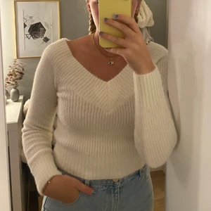 Stickad tröja  - Vit stickad tröja. Sitter väldigt fint. V-ringad både fram och bak. 