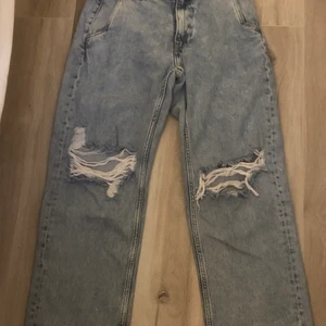 JEANS - ljusblåa vida jeans med hål, knappt använda storlek 29/31