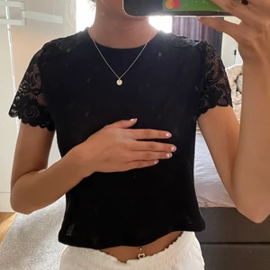 Svart topp - Snygg svart top med spets på axlarna. Den är lite genomskinlig men funkar nog med en hudfärgad bh eller om man vill ha något annat under. Storlek Xs, fint skick 💖 