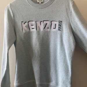 Kenzo jumper grå  - Säljer den här kenzo tröjan på grund av att jag inte har den stillen länger. Jätte fin men ganska liten i stolek skulle säga att det är en S XS kanske. Helt o använda och i bra skick. Säljer den ganska billigt för att jag rensar garderoben och helst vill bli av med kläderna fort men ny pris ligger på 1 300 ungefär, köparen betar för leverans eller möttas upp i Stockholm 