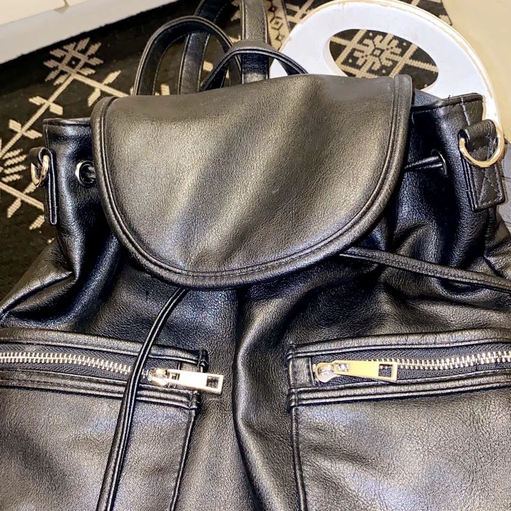En Ryggsäck gjord av läder ny inte använd  svart passar till resa  . Väskor.
