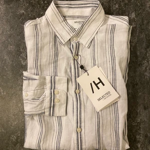 NY! Selected linne skjorta strl: M - Helt NY Skjorta i linne ifrån Selected. Passform: Regular , Strl: Medium , Nypris: 800:- , säljes för 50%. Härlig tunn linneskjorta att förbereda inför sommaren , löst sittande i regular passform. Rekommenderas att skicka med spårbar frakt , men köparen får givetvis bestämma valfritt fraktalternativ. . Kommer att skicka konfirmationer när plaggen är skickade och följa upp under leveransen tills varan är framme. Har ni några frågor är det bara att kontakta mig.