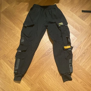 Jättesköna cargobyxor - Svarta cargobyxor med snöre i midjan och många fickor. Bra skick och inga hål. Dom är använda ett fåtal gånger men har tyvärr inga lappar kvar
