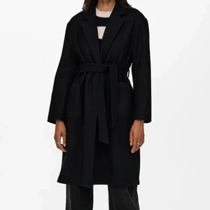 Svarta kappa med midjeskärp - Säljer denna populära och slutsålda kappan från Only som är så fin och helt ny, kappan är av bra kvalitet och ser dyr ut! Storlek S! Nypris 700kr!