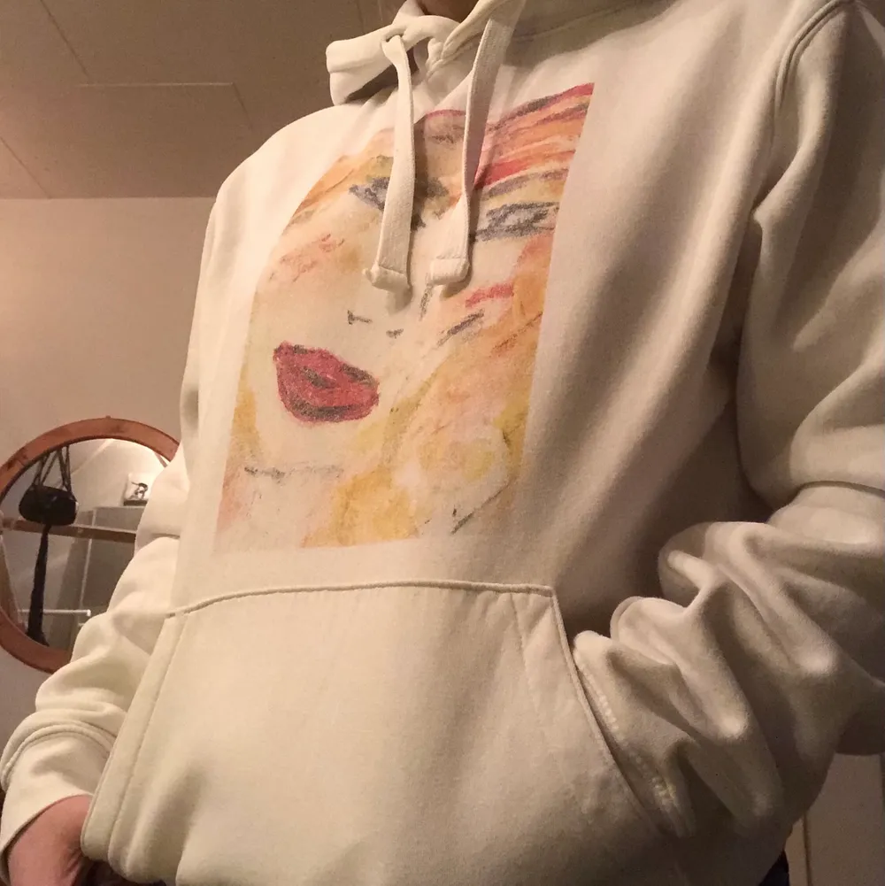 Vit hoodie med tryck både bak och fram. Knappt använd så väldigt bra skick! Nypris: 599kr.. Hupparit & Collegepaidat.