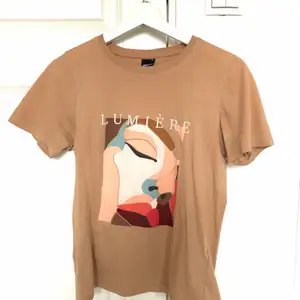 Beige t-shirt med tryck. Köpt på ginatricot. Nyskick!