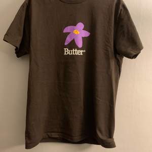 Brun Butter T-shirt med lila blommor fram och bak i strl M lite liten i storleken så passar S också väldigt bra skick köpt för 350 på caliroots