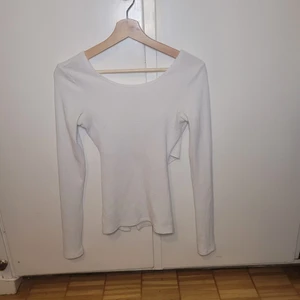 Långärmad ribbad topp - Ribbad top med överlappande tyg i bak.